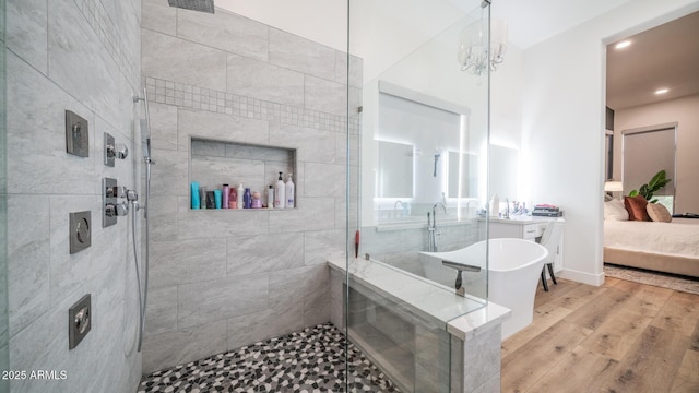 bathroom featuring hardwood / wood-style flooring, independent shower and bath, and a chandelier