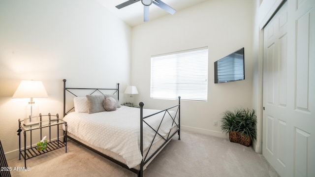 carpeted bedroom featuring ceiling fan and a closet