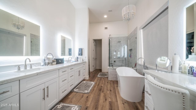 bathroom with hardwood / wood-style flooring, vanity, a notable chandelier, and plus walk in shower