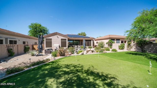 rear view of property featuring solar panels