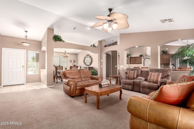 living room featuring vaulted ceiling, light carpet, and ceiling fan with notable chandelier