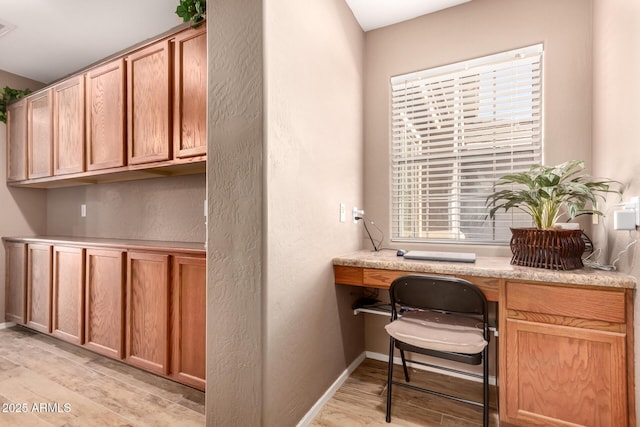 home office with light hardwood / wood-style flooring