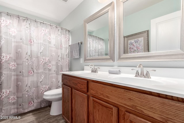 bathroom with hardwood / wood-style flooring, vanity, and toilet