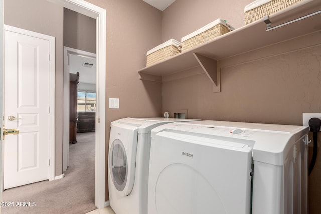 laundry room with washer and dryer and light carpet