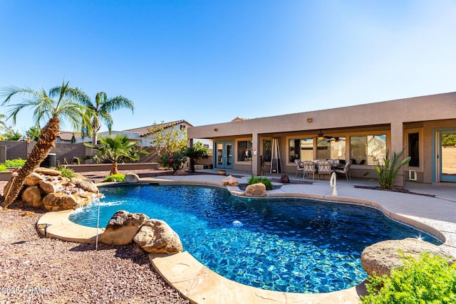 view of pool featuring pool water feature, french doors, ceiling fan, and a patio