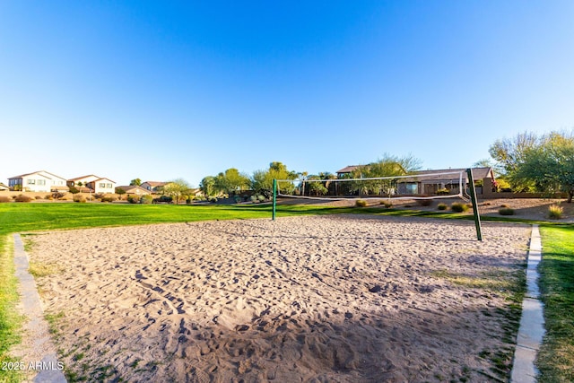 surrounding community with volleyball court and a lawn