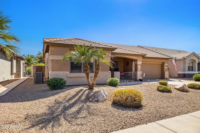 ranch-style home featuring central AC unit and a garage