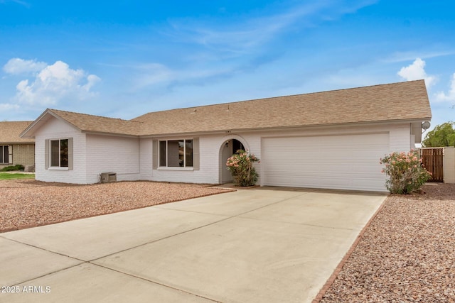 ranch-style house with concrete driveway, brick siding, a garage, and a shingled roof