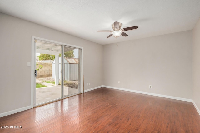 empty room featuring a ceiling fan, wood finished floors, and baseboards