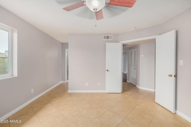 unfurnished bedroom featuring light tile patterned floors, baseboards, and ceiling fan