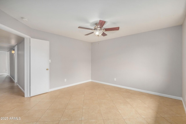 unfurnished room with a ceiling fan, light tile patterned floors, and baseboards