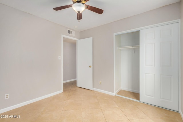 unfurnished bedroom with light tile patterned flooring, baseboards, a closet, and ceiling fan