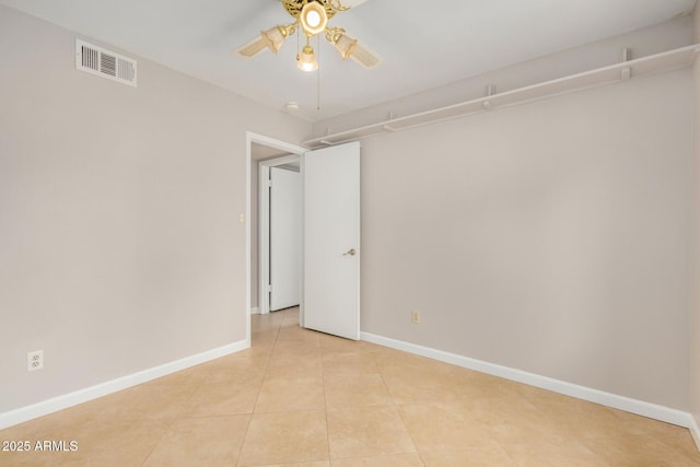 empty room featuring a ceiling fan, baseboards, and light tile patterned flooring