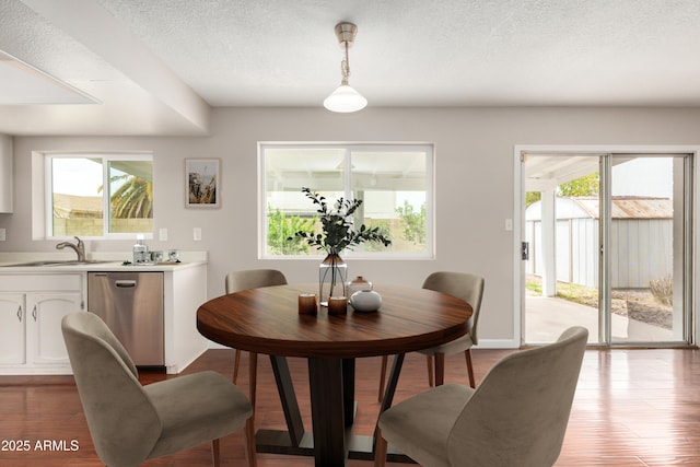dining area featuring plenty of natural light, a textured ceiling, and wood finished floors