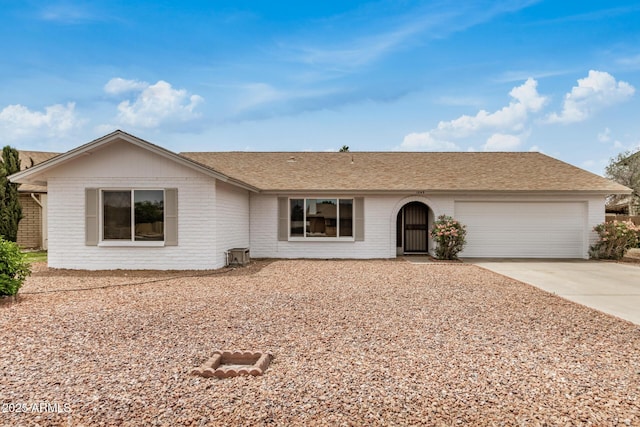 ranch-style home featuring concrete driveway, an attached garage, brick siding, and a shingled roof