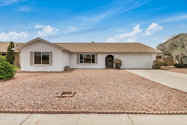 single story home featuring concrete driveway, an attached garage, and brick siding