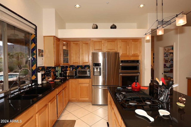 kitchen featuring sink, light tile patterned floors, stainless steel appliances, decorative backsplash, and decorative light fixtures