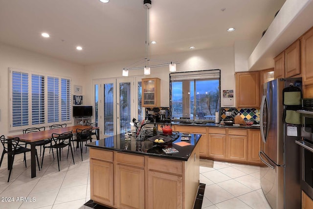 kitchen with a kitchen island, pendant lighting, stainless steel refrigerator, and light tile patterned floors