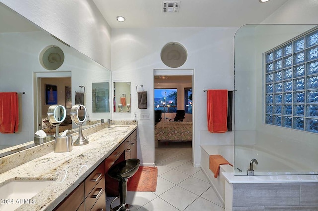 bathroom with vanity, tile patterned floors, and tiled bath