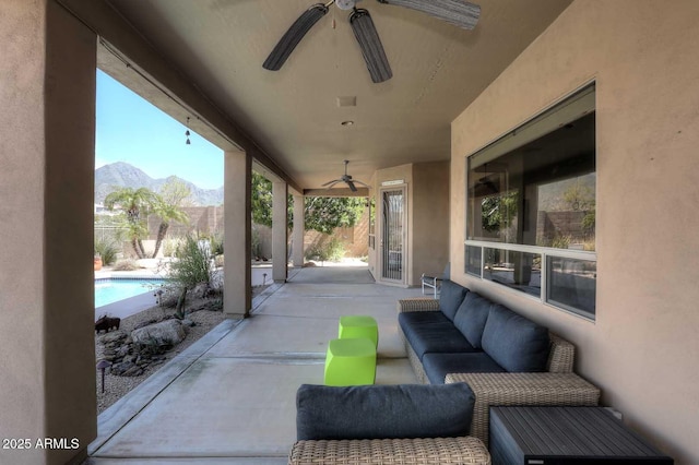 view of patio with a mountain view, an outdoor hangout area, a fenced in pool, and ceiling fan