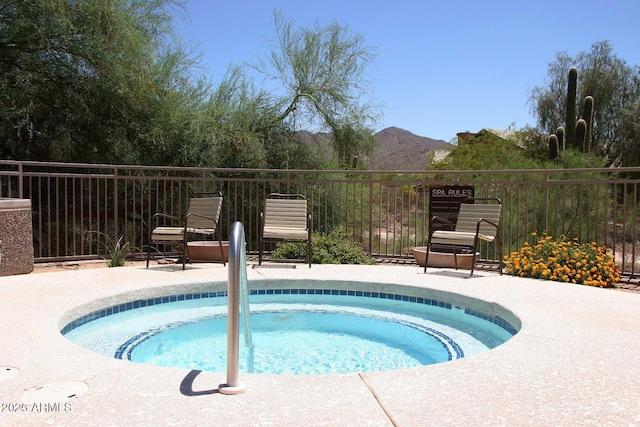 view of pool with a mountain view, a patio area, and an in ground hot tub