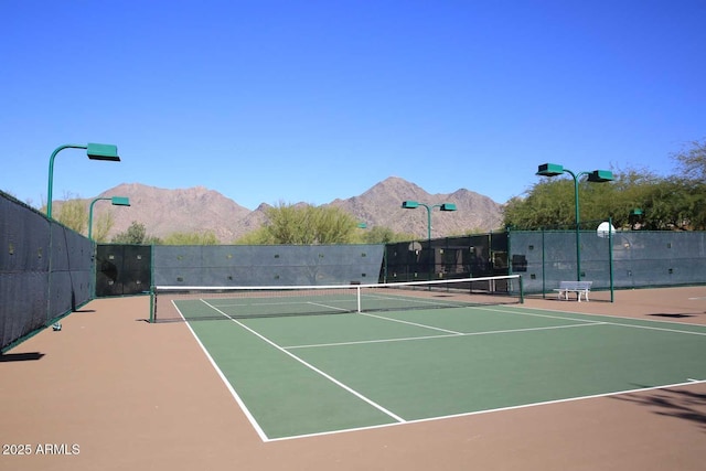 view of tennis court featuring a mountain view and basketball hoop