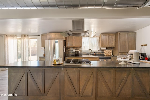 kitchen featuring tasteful backsplash, dark countertops, appliances with stainless steel finishes, extractor fan, and a sink