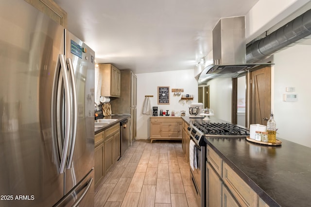 kitchen featuring appliances with stainless steel finishes, wood finish floors, dark countertops, and island range hood