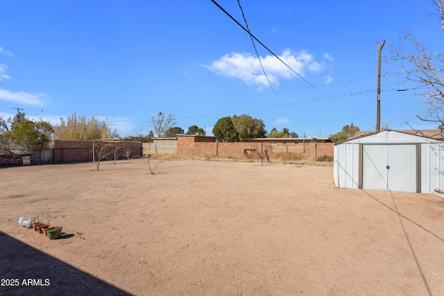 view of yard featuring an outdoor structure, fence, and a shed