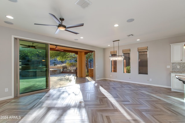 kitchen with light parquet floors, white cabinets, ceiling fan, decorative backsplash, and decorative light fixtures