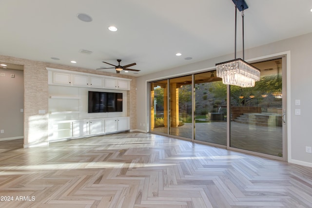 unfurnished living room featuring light parquet flooring and ceiling fan with notable chandelier