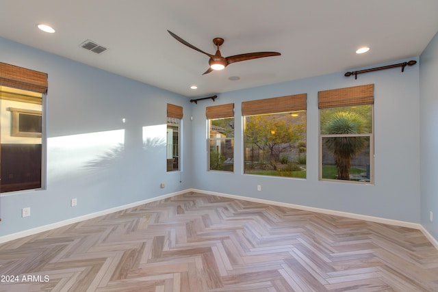 empty room with light parquet floors and ceiling fan