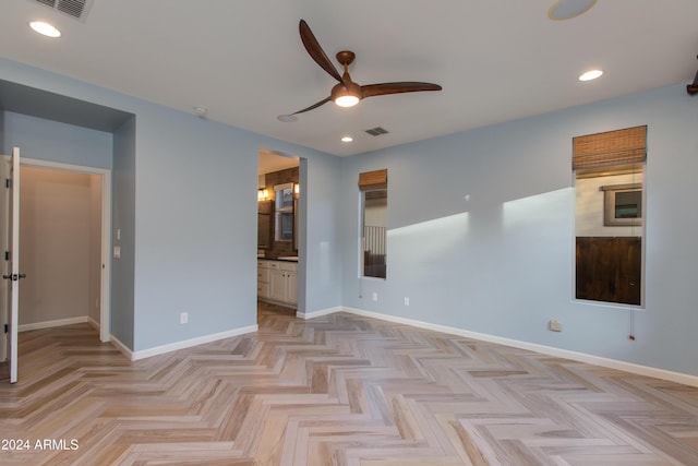 spare room with ceiling fan and light parquet flooring