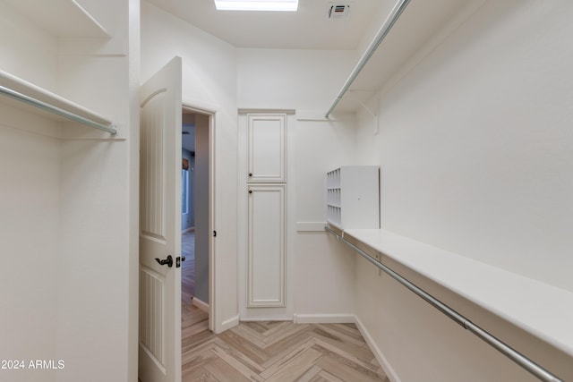 spacious closet with light parquet flooring