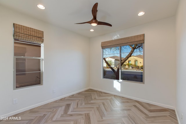 empty room with ceiling fan and light parquet flooring