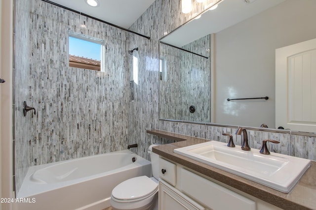 full bathroom with tiled shower / bath, vanity, tile walls, and toilet