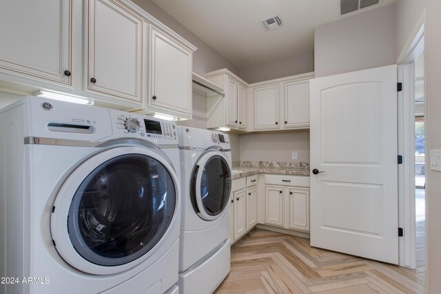 clothes washing area with cabinets, separate washer and dryer, and light parquet flooring