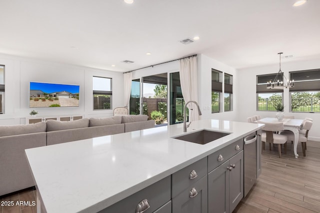 kitchen with a sink, visible vents, gray cabinetry, and open floor plan