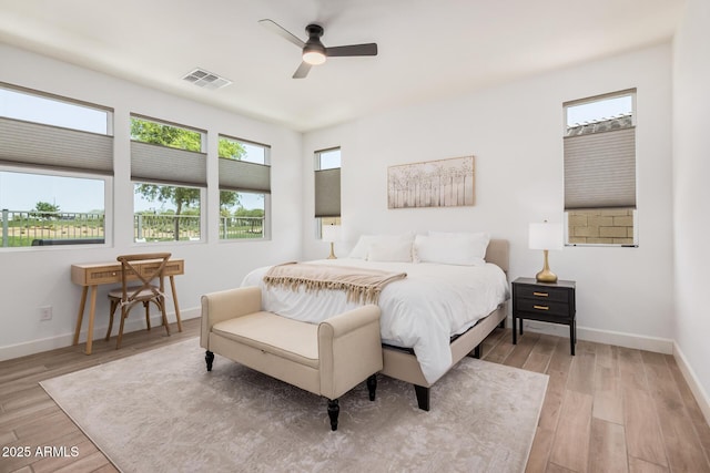 bedroom featuring baseboards, multiple windows, light wood finished floors, and visible vents