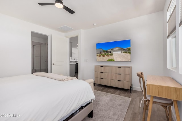 bedroom featuring visible vents, wood finished floors, baseboards, connected bathroom, and a ceiling fan