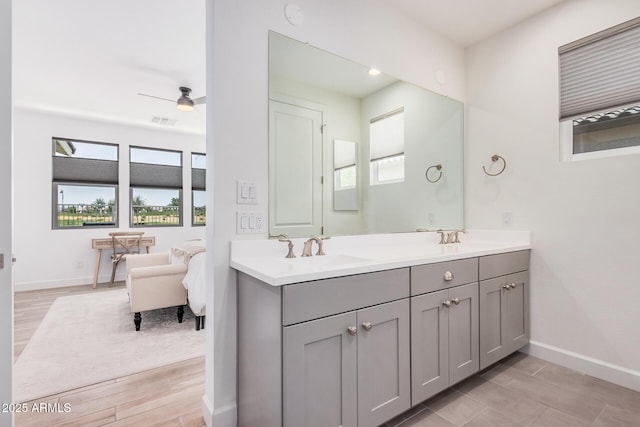ensuite bathroom featuring a sink, baseboards, double vanity, and visible vents
