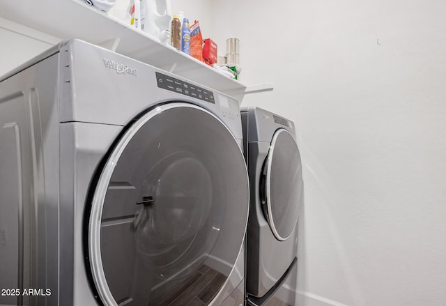 laundry room with laundry area, baseboards, wood finished floors, and separate washer and dryer