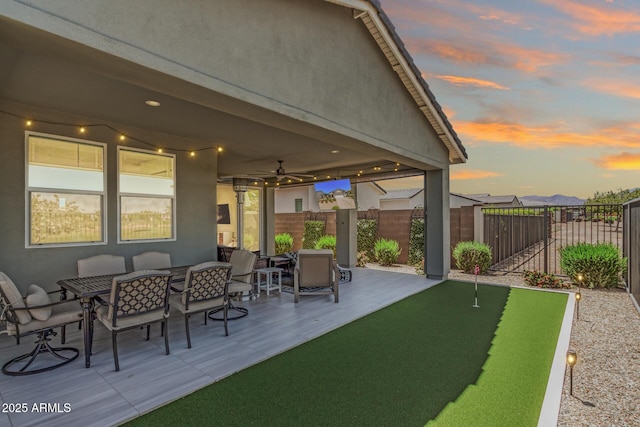 view of patio featuring outdoor dining area, a ceiling fan, and fence