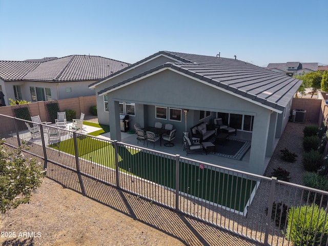 back of house featuring a tile roof, stucco siding, outdoor lounge area, a fenced backyard, and cooling unit