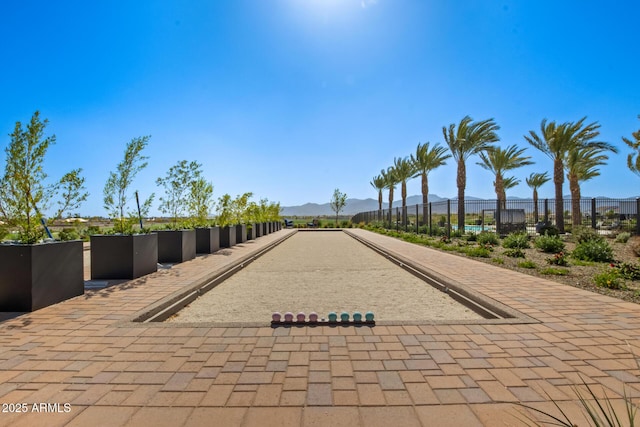 surrounding community with a mountain view and fence