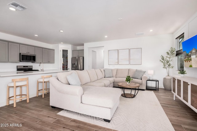living area featuring recessed lighting, dark wood finished floors, and visible vents