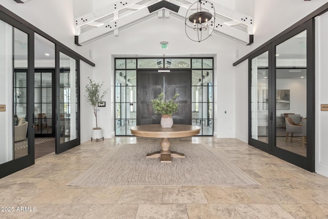 foyer entrance with stone tile floors, a wealth of natural light, and french doors