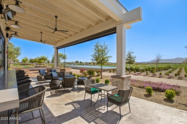 view of patio with ceiling fan and a mountain view