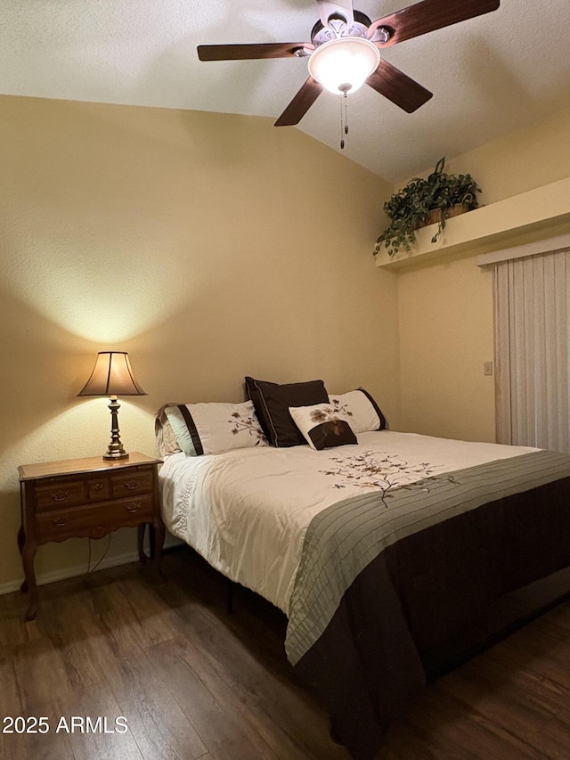 bedroom with vaulted ceiling, dark wood-type flooring, and ceiling fan