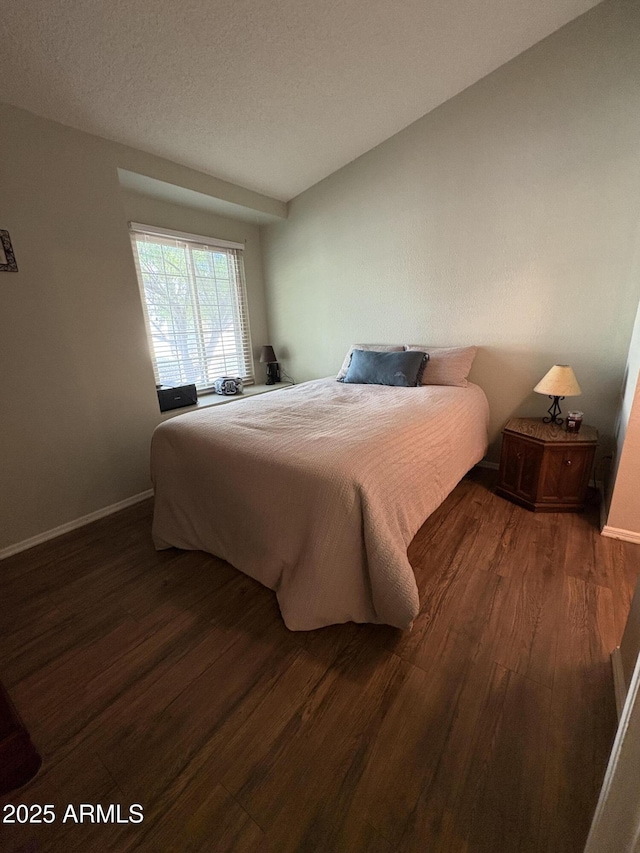 bedroom featuring dark hardwood / wood-style flooring and a textured ceiling